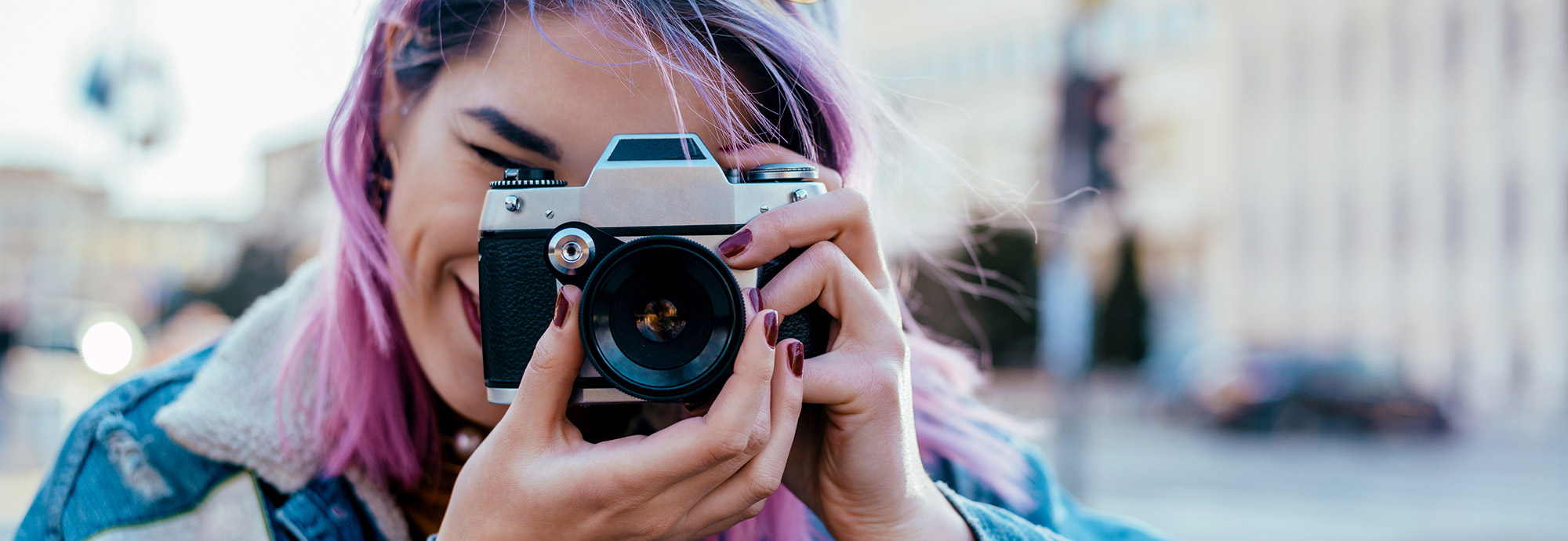Une jeune personne tient une caméra et prend une photo pour l'Espace de création de la communauté Libère tes émotions de Jeunesse, J'écoute.